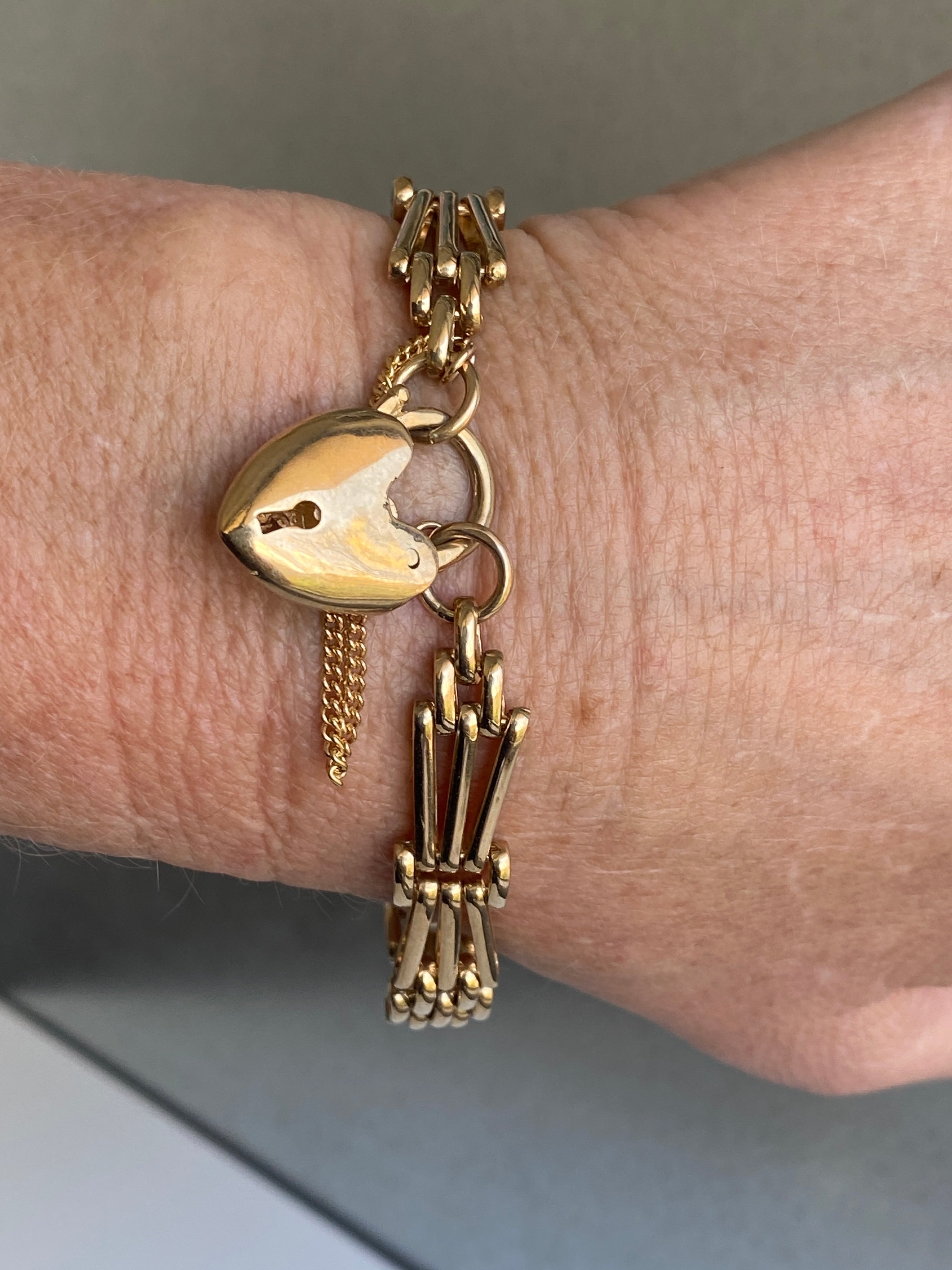 A vintage 9ct yellow gold gate-link bracelet with a heart-shaped padlock.