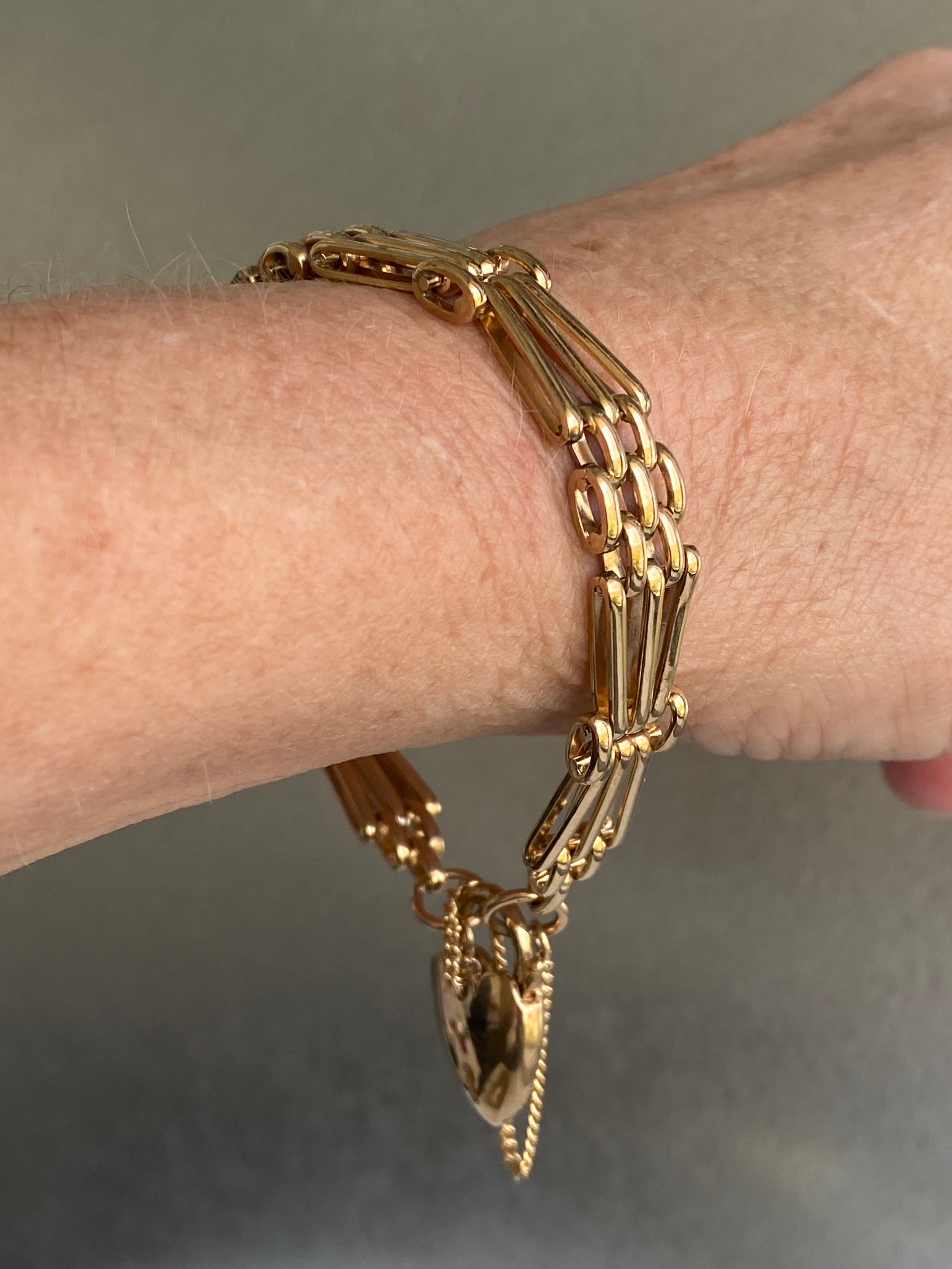 A vintage 9ct yellow gold gate-link bracelet with a heart-shaped padlock.