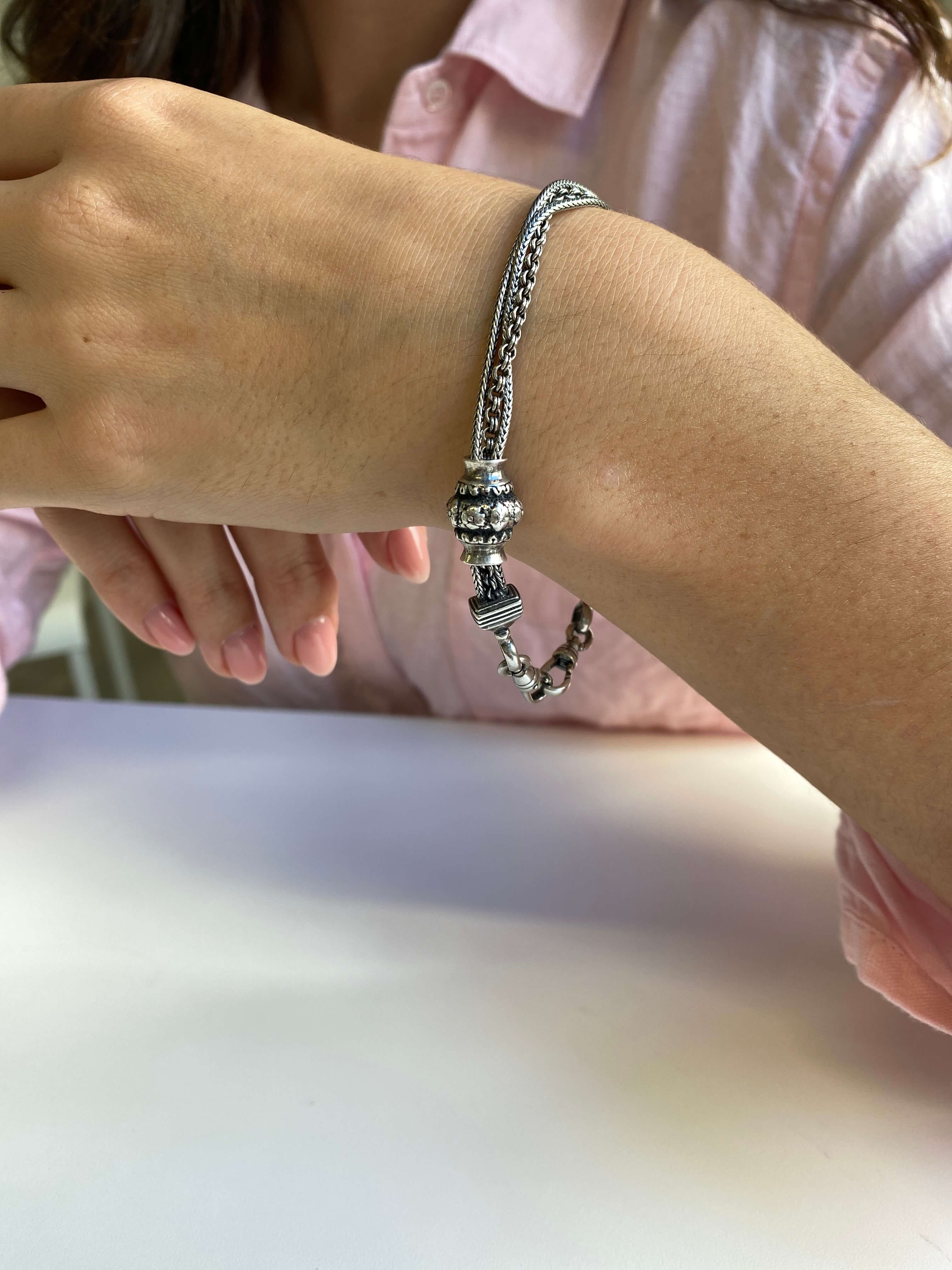 Antique Style Silver Albertina Bracelet, of triple strand design, and hung with two swivel catches and barrel shaped slide with floral decoration.