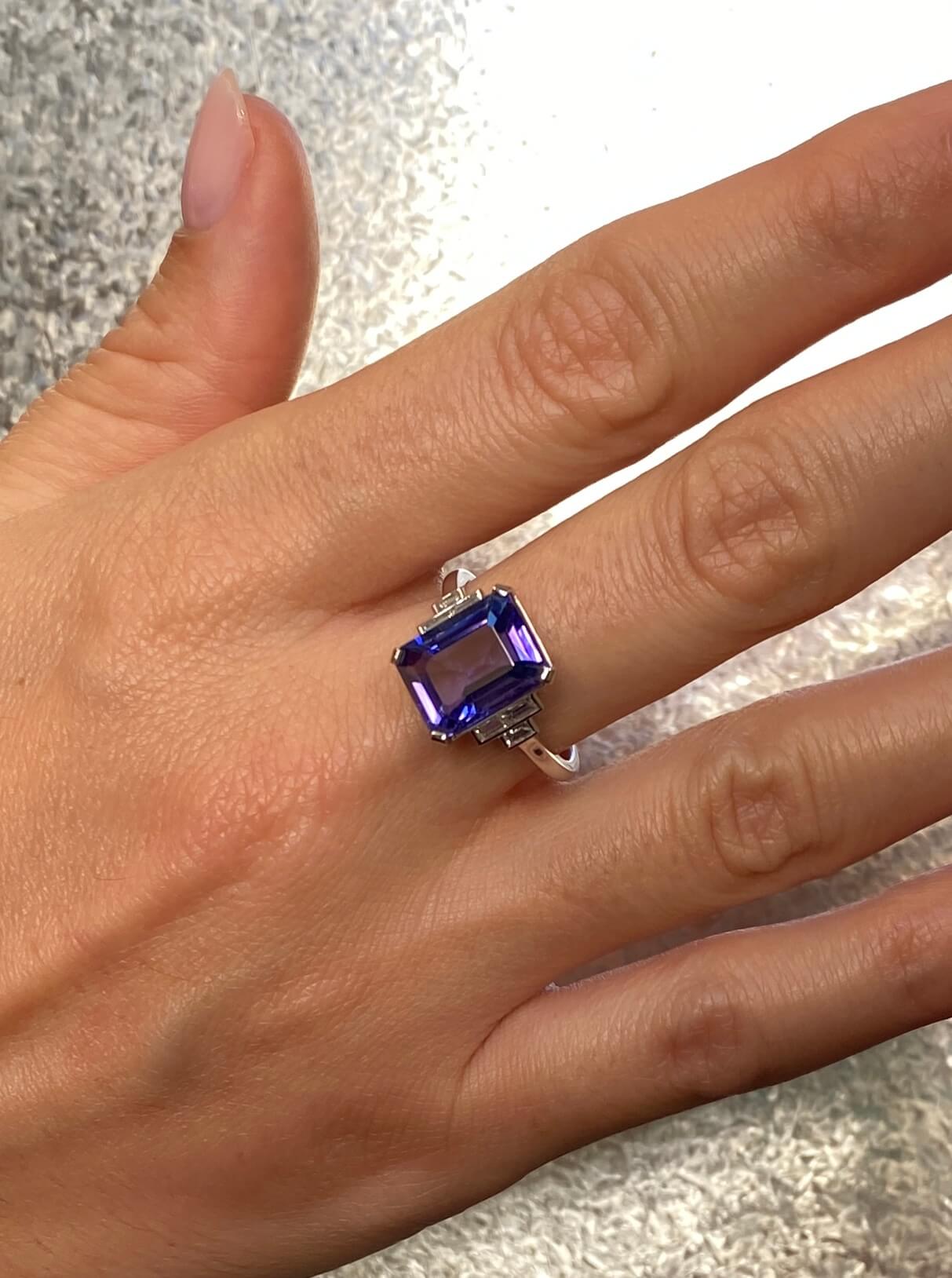 Art Deco Style Tanzanite and Diamond Ring. An elegant ring set with an 4.54 carat emerald-cut tanzanite and baguette-cut diamonds. Platinum.