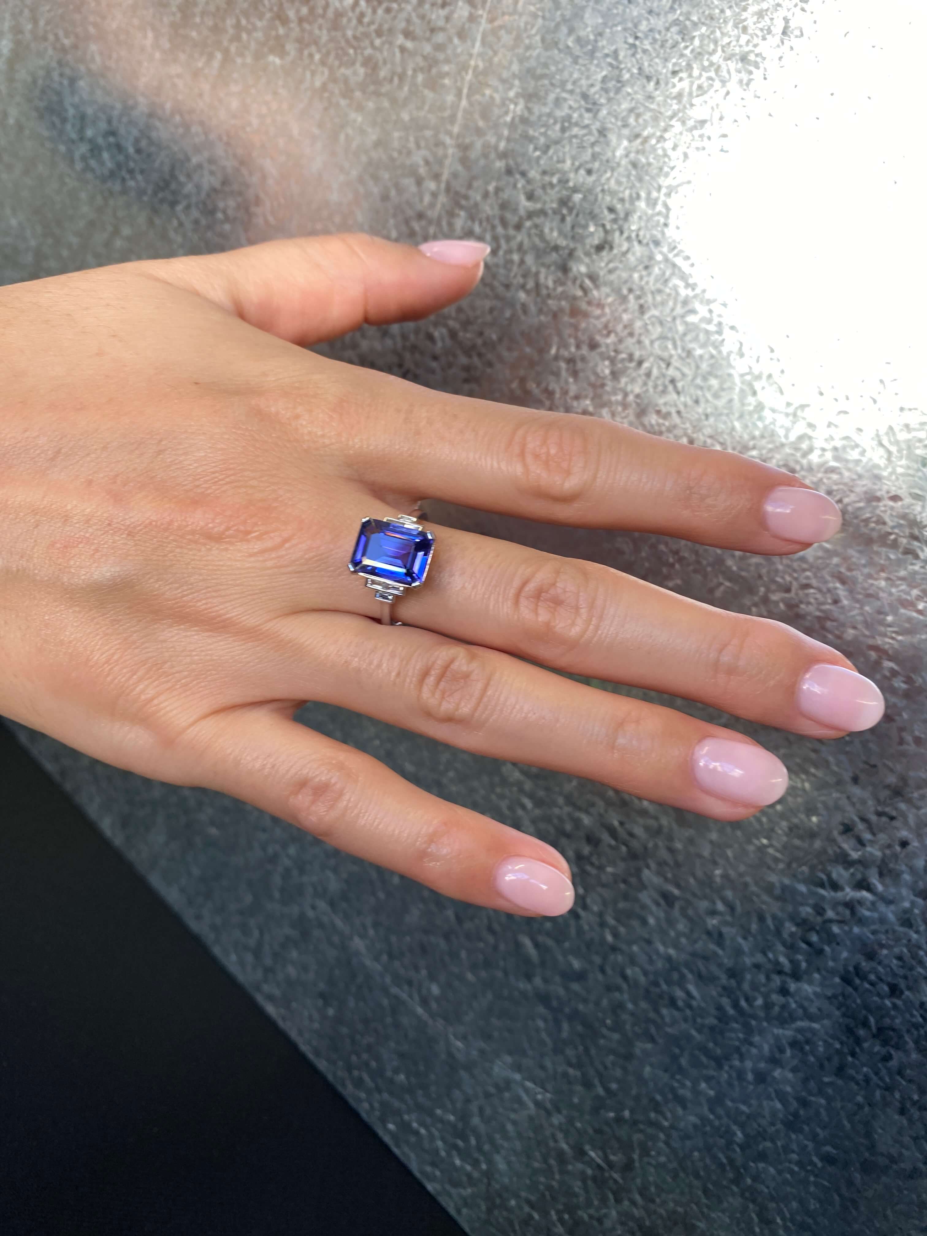 Art Deco Style Tanzanite and Diamond Ring. An elegant ring set with an 4.54 carat emerald-cut tanzanite and baguette-cut diamonds. Platinum.