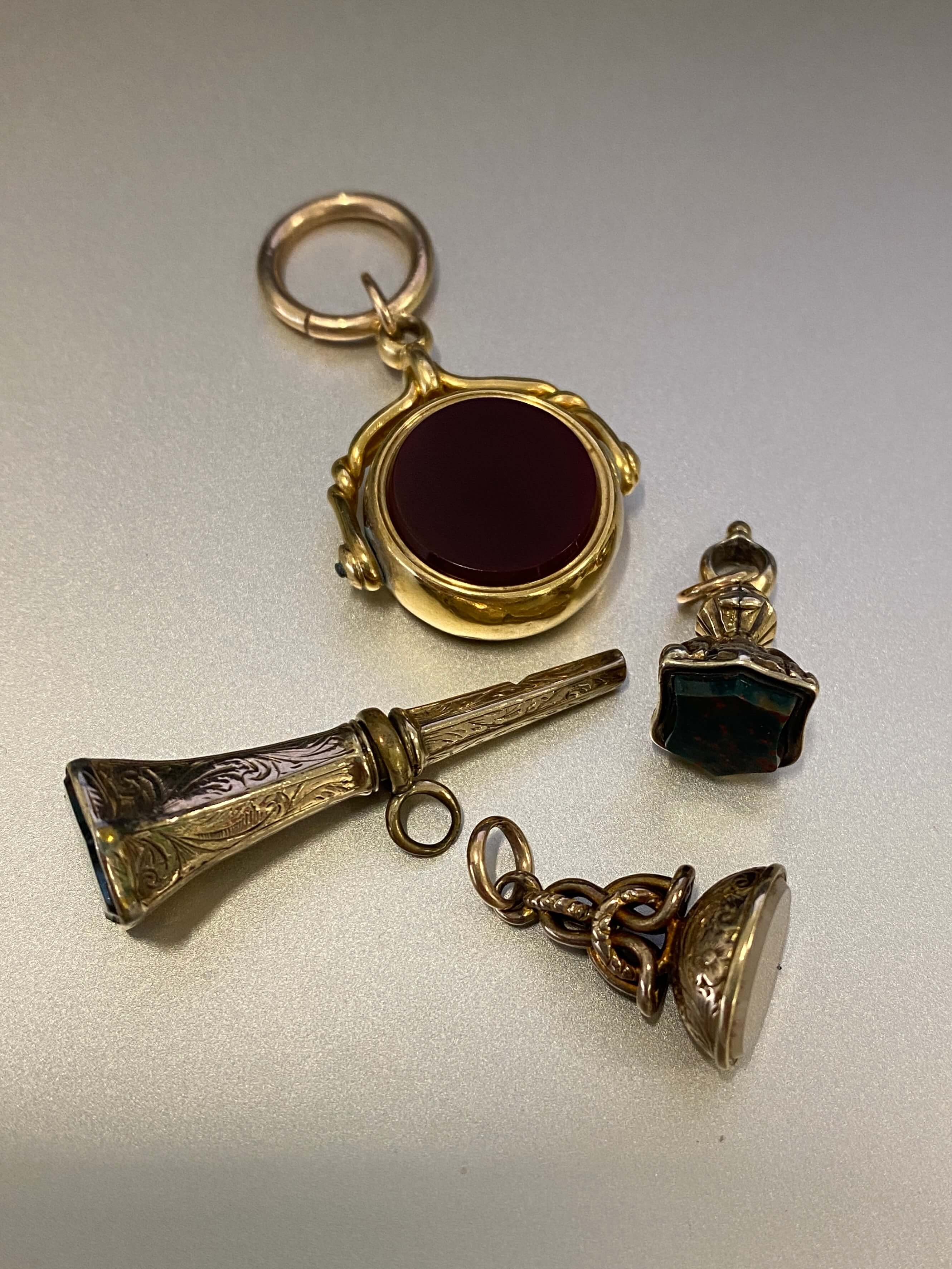 A group of gold mounted seals, spinner and watch key, each set with agate