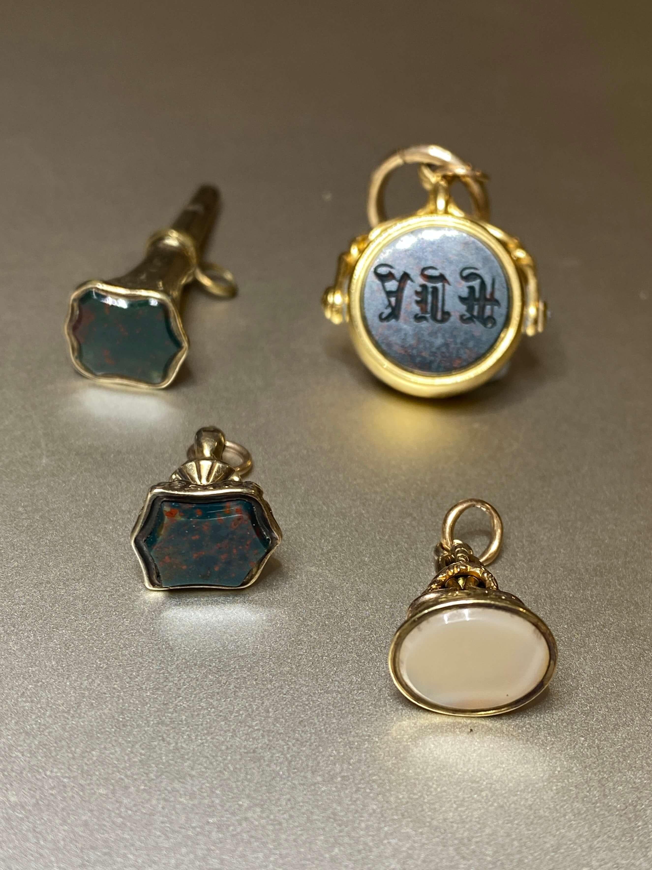 A group of gold mounted seals, spinner and watch key, each set with agate