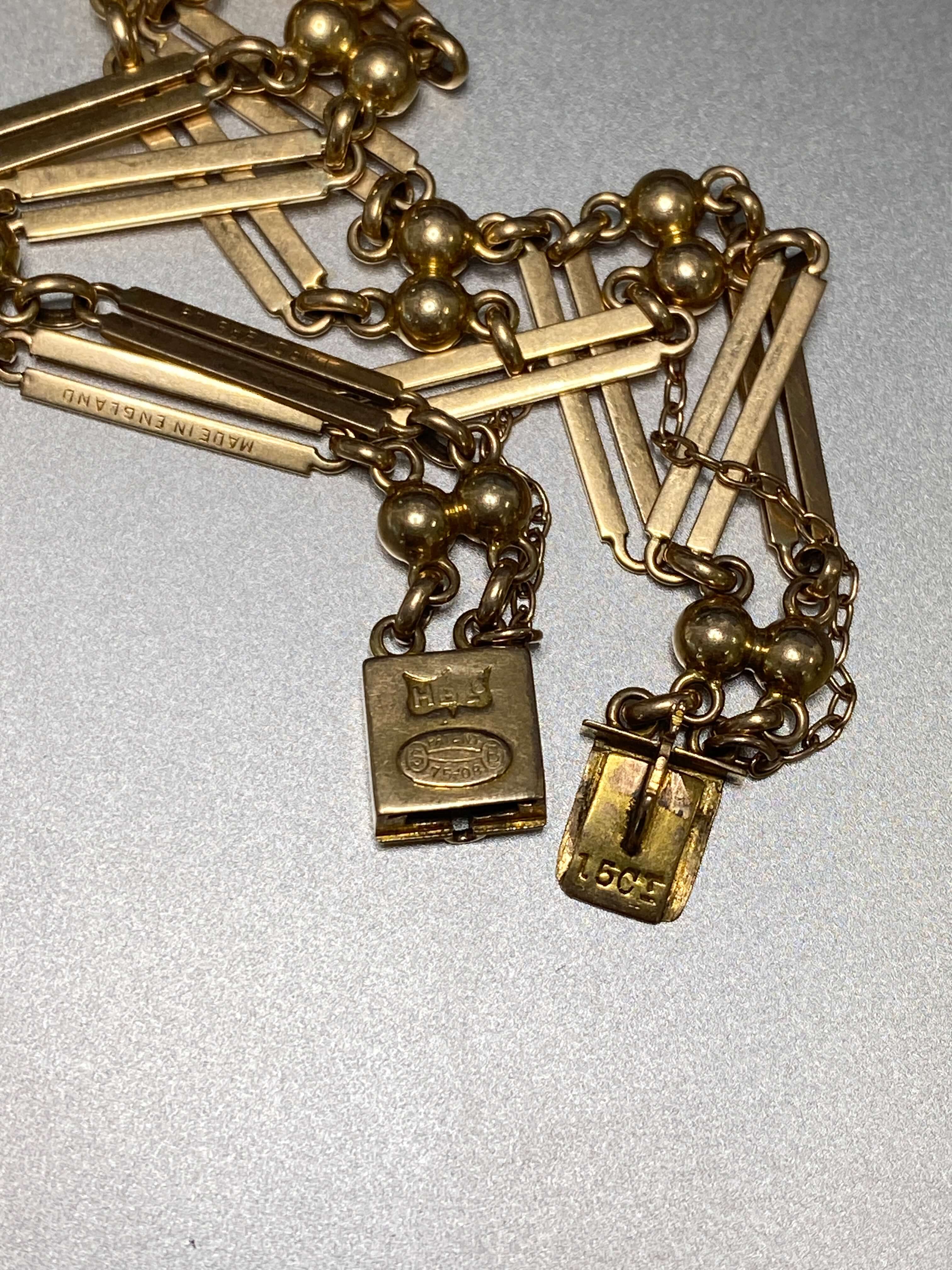 Antique yellow gold double bar gate bracelet with English hallmarks on silver background
