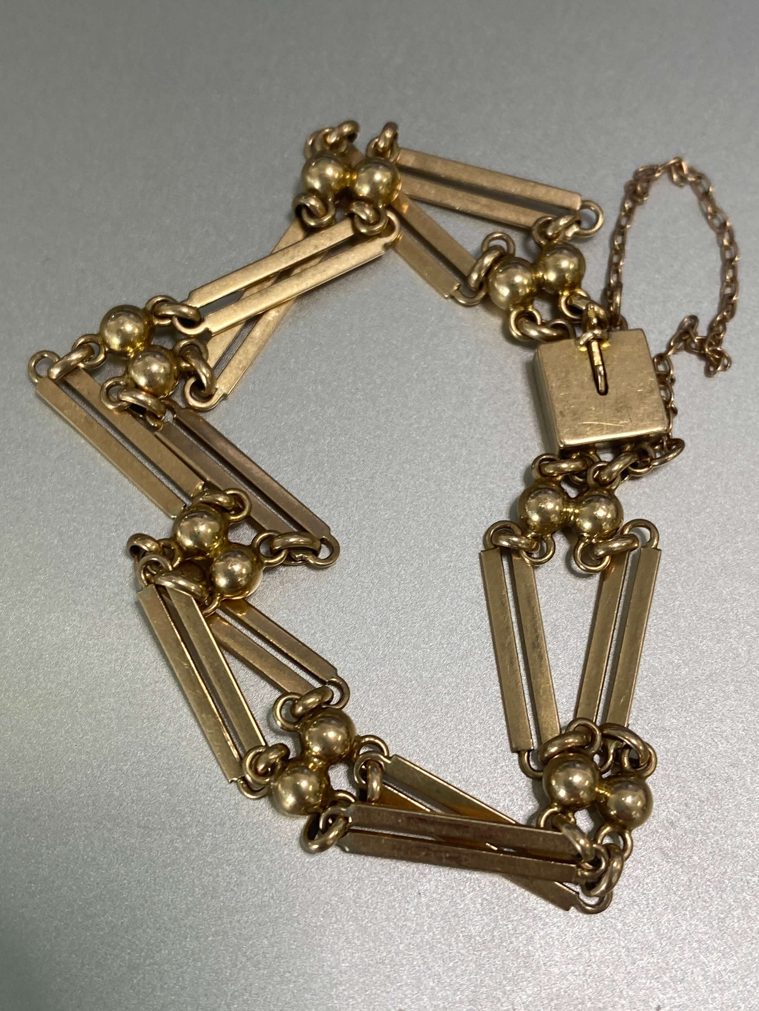 Antique yellow gold double bar bracelet on silver background