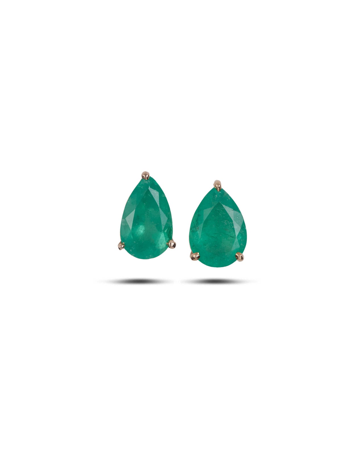 A pair of pear=shaped emerald stud earrings on a white background
