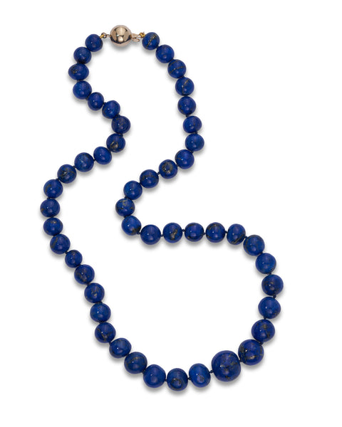 A beaded necklace made of dark blue lapis lazuli off-round beads with natural golden flecks, featuring a polished gold clasp at the top, displayed on a clean white background.