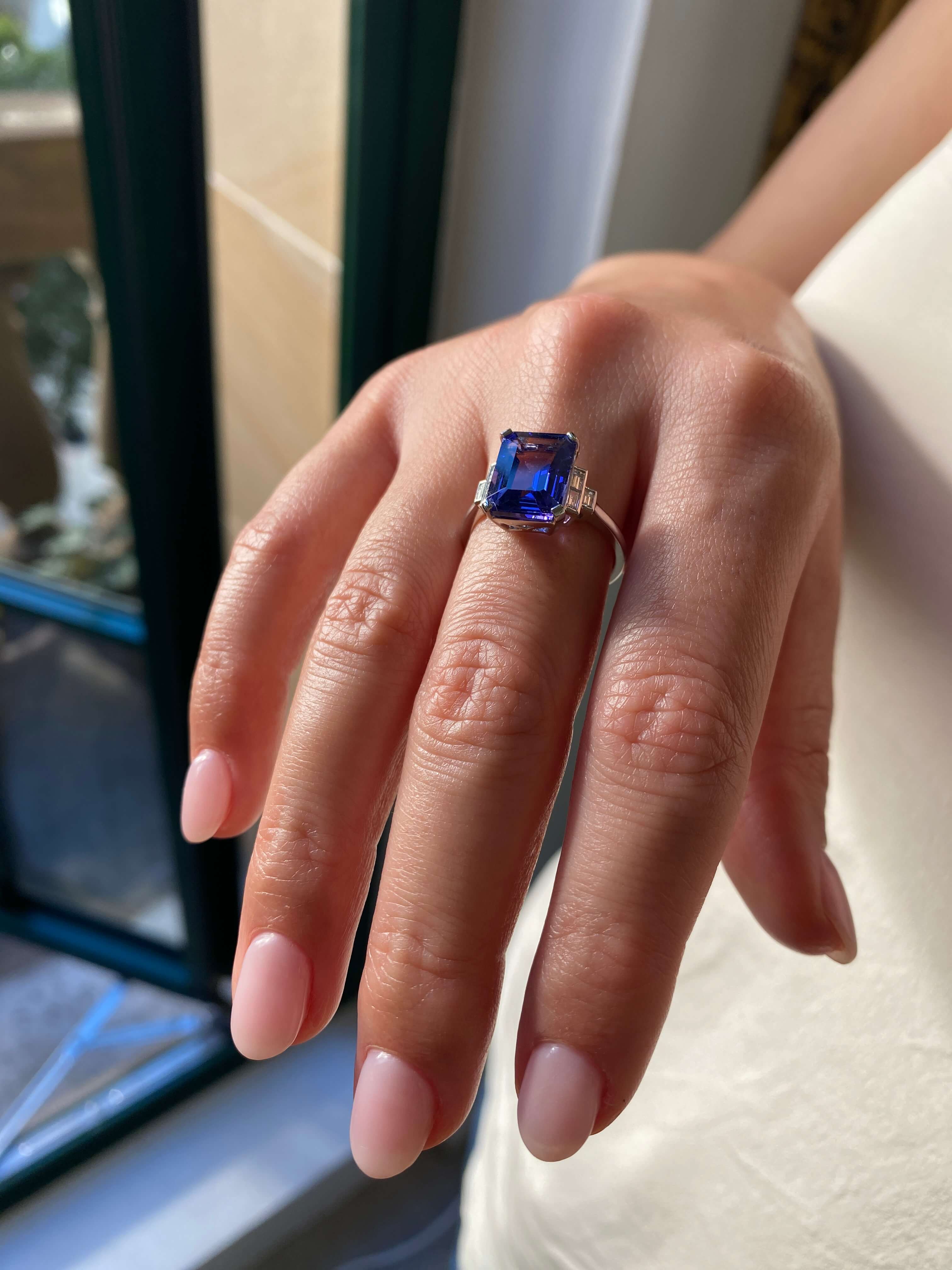 Art Deco Style Tanzanite and Diamond Ring. An elegant ring set with an 4.54 carat emerald-cut tanzanite and baguette-cut diamonds. Platinum.
