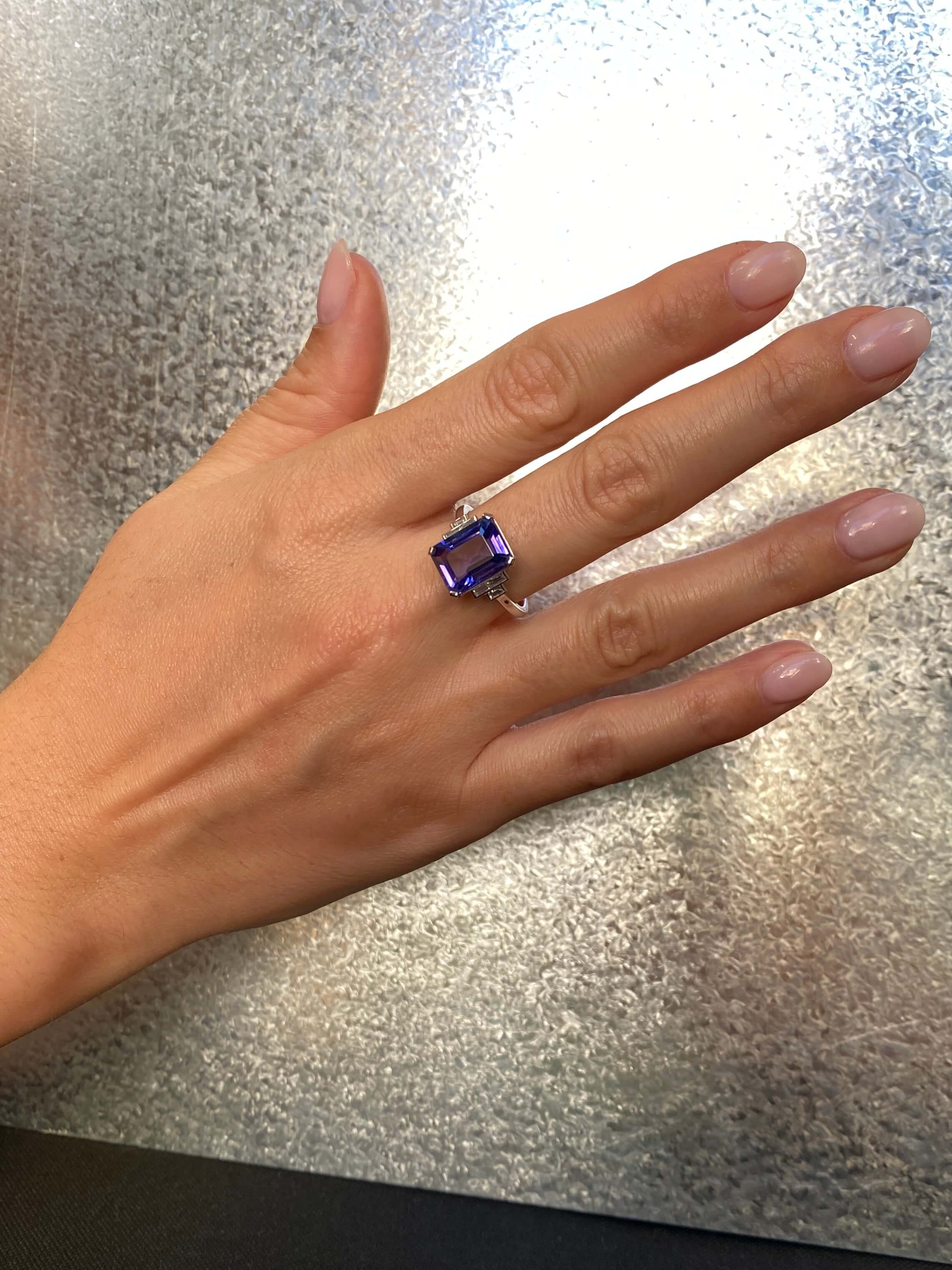 Art Deco Style Tanzanite and Diamond Ring. An elegant ring set with an 4.54 carat emerald-cut tanzanite and baguette-cut diamonds. Platinum.
