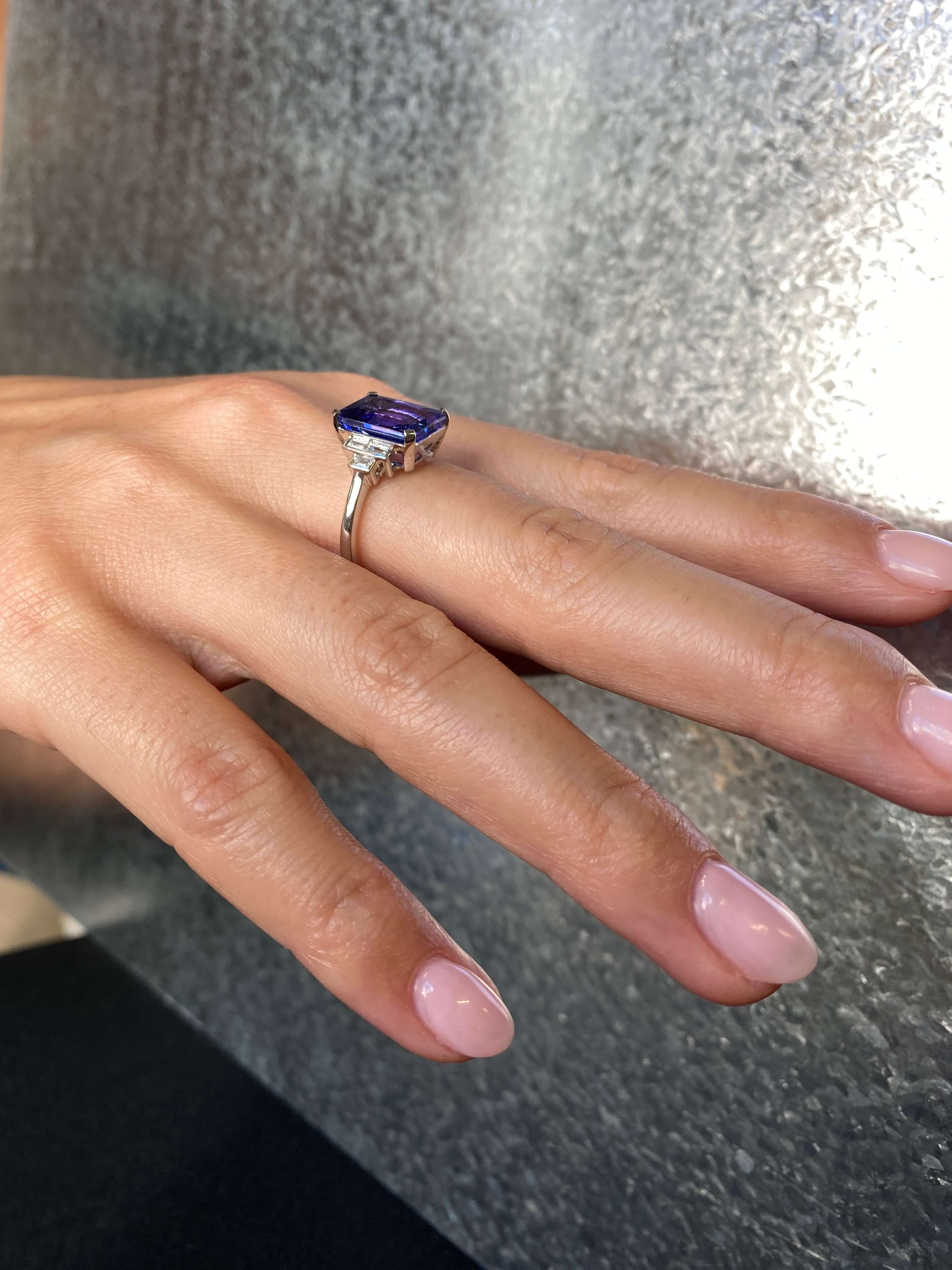 Art Deco Style Tanzanite and Diamond Ring. An elegant ring set with an 4.54 carat emerald-cut tanzanite and baguette-cut diamonds. Platinum.