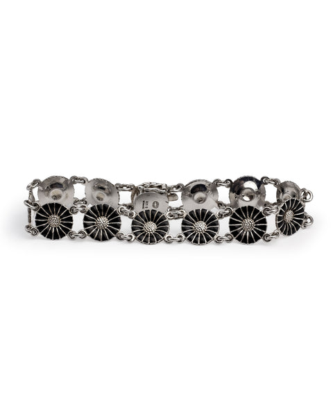 eorg Jensen, Silver & Enamel Daisy Bracelet from the iconic Daisy collection, featuring six round floral links with black enamel petals radiating from a domed, textured silver centre. 