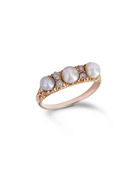 An antique yellow gold ring featuring three large white pearls and four small clear diamonds, set on an ornate filigree band against a white background.